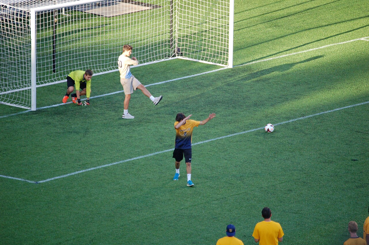 A goal celebration in front of the net — the scorer strikes a pose